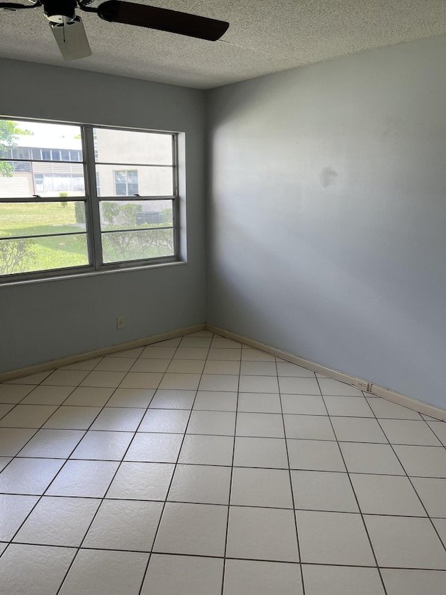 unfurnished room with a textured ceiling, baseboards, and a ceiling fan
