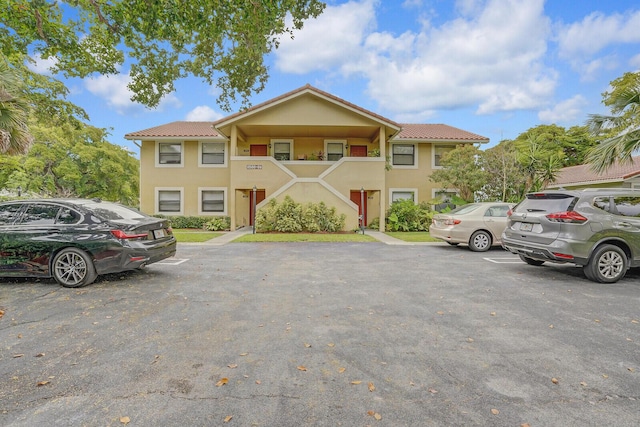 11500 NW 42nd St Unit 1-4, Coral Springs, FL 33065 - view of property with uncovered parking, stucco siding, and a tiled roof