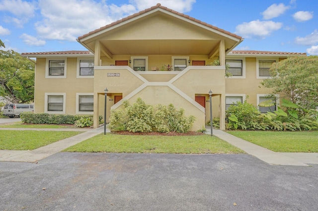 11500 NW 42nd St Unit 1-4, Coral Springs, FL 33065 - view of property featuring stucco siding, a tile roof, and a front yard