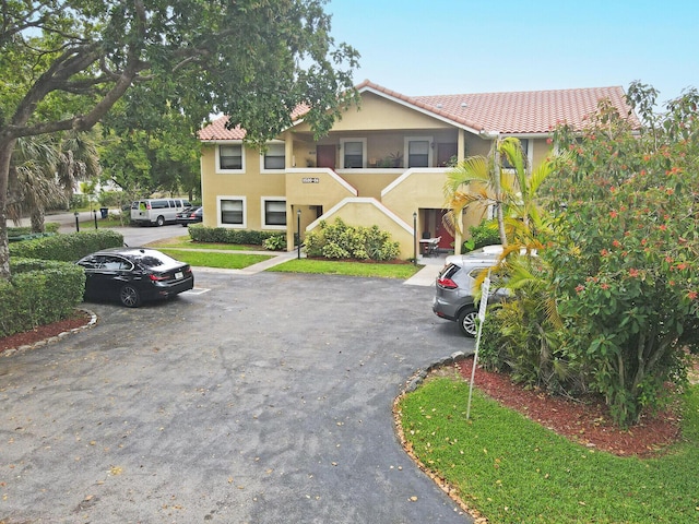 11500 NW 42nd St Unit 1-4, Coral Springs, FL 33065 - view of front of property with stucco siding, a tile roof, and uncovered parking