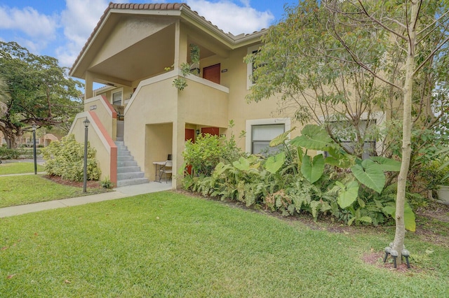11500 NW 42nd St Unit 1-4, Coral Springs, FL 33065 - view of front facade featuring stucco siding, stairway, a front lawn, and a tiled roof