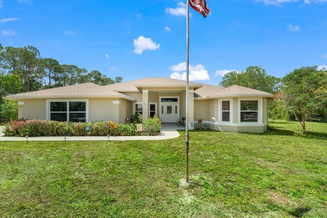 view of front facade with a front yard and stucco siding