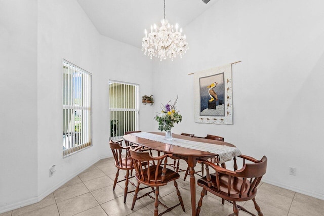 dining area with high vaulted ceiling, a chandelier, light tile patterned floors, and baseboards