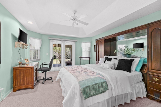 bedroom with carpet floors, access to outside, a ceiling fan, baseboards, and a tray ceiling