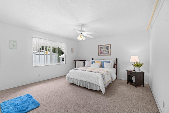 carpeted bedroom with a ceiling fan and baseboards