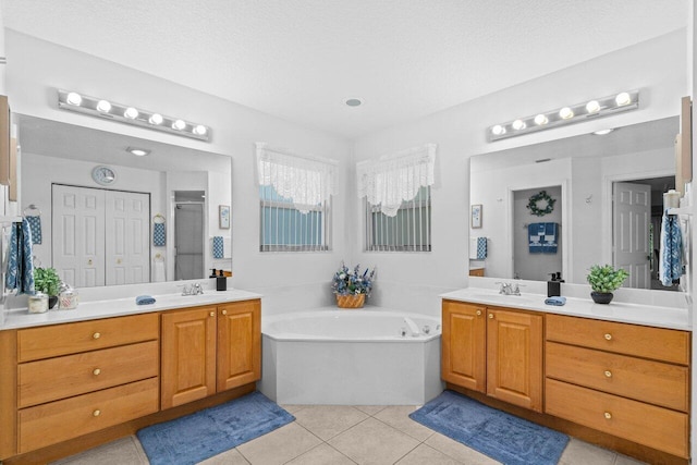 bathroom featuring a shower stall, tile patterned floors, two vanities, and a garden tub