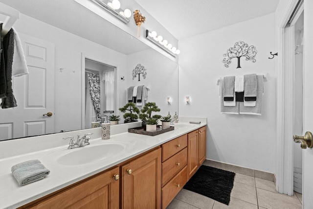 full bathroom featuring tile patterned flooring, double vanity, and baseboards