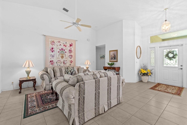 living room featuring high vaulted ceiling, tile patterned flooring, a ceiling fan, baseboards, and a chandelier