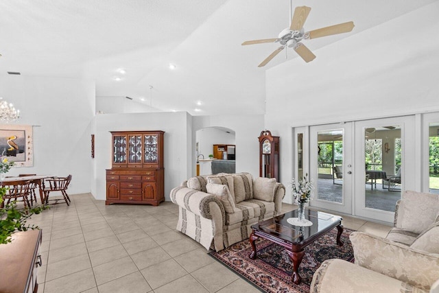 living area featuring arched walkways, light tile patterned floors, ceiling fan, french doors, and high vaulted ceiling