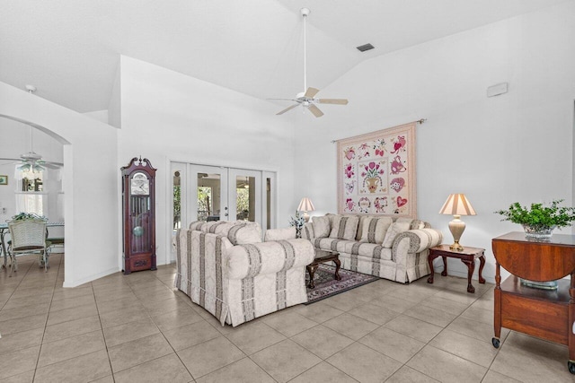 living area featuring ceiling fan, light tile patterned floors, french doors, plenty of natural light, and high vaulted ceiling