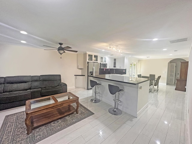 3946 A St, Palm Springs, FL 33461 - living room featuring arched walkways, recessed lighting, a ceiling fan, light wood-type flooring, and baseboards