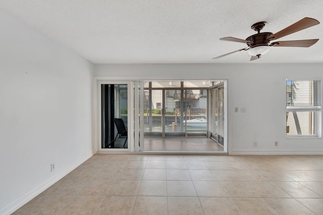 1100 Russell Dr, Highland Beach, FL 33487 - empty room with plenty of natural light, tile patterned floors, baseboards, and a ceiling fan