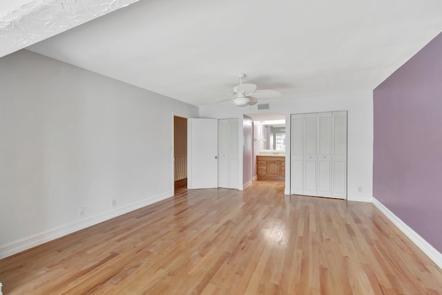 1100 Russell Dr, Highland Beach, FL 33487 - unfurnished bedroom with light wood-style flooring, baseboards, ceiling fan, and multiple closets
