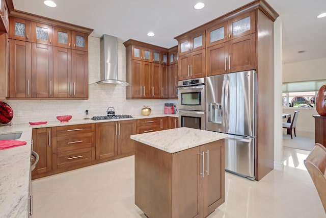 391 Glenbrook Dr, Atlantis, FL 33462 - kitchen with stainless steel appliances, wall chimney range hood, backsplash, light stone counters, and brown cabinets
