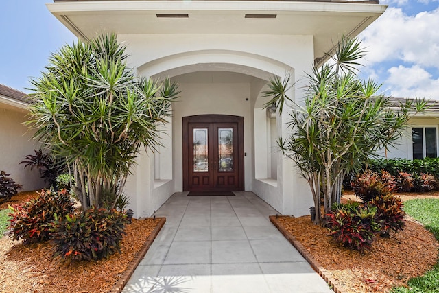 391 Glenbrook Dr, Atlantis, FL 33462 - view of exterior entry with stucco siding and french doors