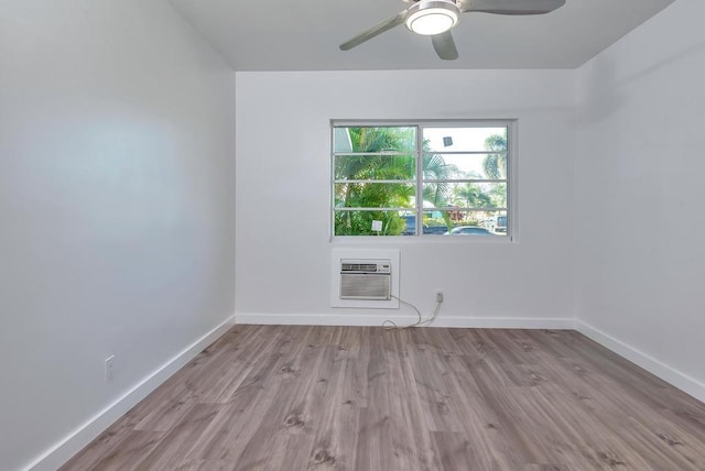 unfurnished room with a wall mounted AC, baseboards, ceiling fan, and wood finished floors