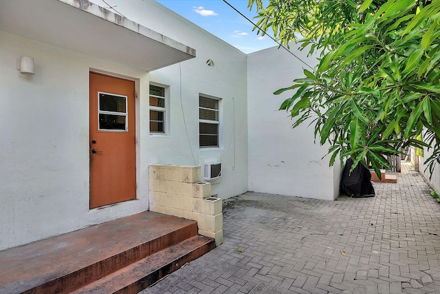 property entrance with stucco siding and a patio area
