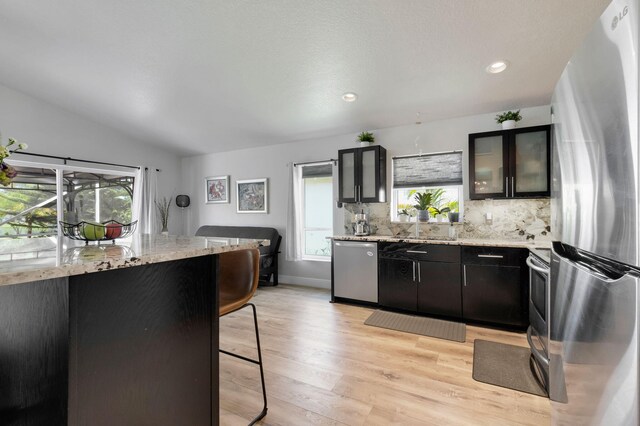 18834 Caspian Cir, Boca Raton, FL 33496 - kitchen featuring stainless steel appliances, light wood-type flooring, lofted ceiling, glass insert cabinets, and tasteful backsplash