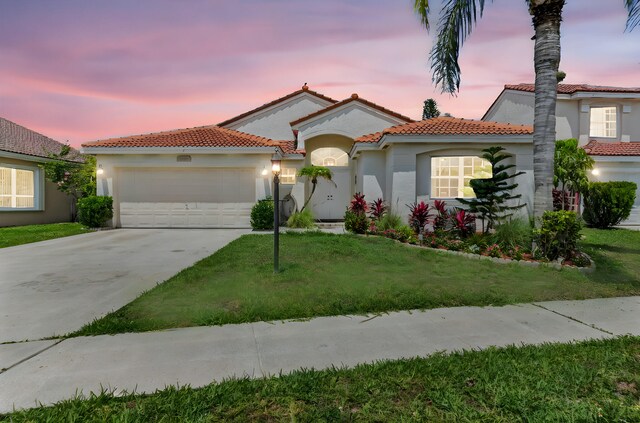 18834 Caspian Cir, Boca Raton, FL 33496 - mediterranean / spanish home featuring an attached garage, stucco siding, concrete driveway, a tiled roof, and a front yard