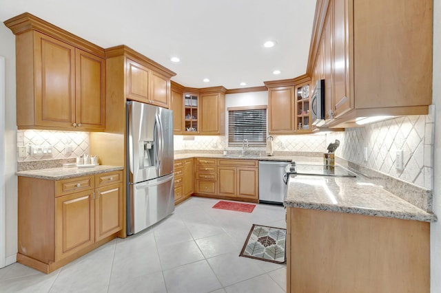 kitchen featuring stainless steel appliances, light stone countertops, backsplash, glass insert cabinets, and recessed lighting