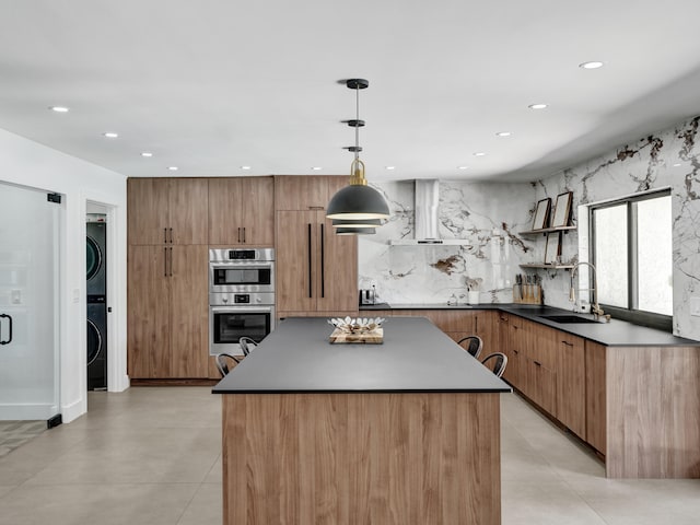 2708 NW 26th Cir, Boca Raton, FL 33431 - kitchen with a sink, wall chimney range hood, stacked washer / drying machine, double oven, and modern cabinets