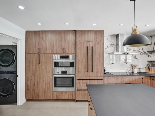 2708 NW 26th Cir, Boca Raton, FL 33431 - kitchen featuring stacked washer and clothes dryer, wall chimney exhaust hood, double oven, dark countertops, and recessed lighting