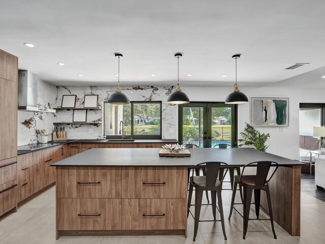 2708 NW 26th Cir, Boca Raton, FL 33431 - kitchen with modern cabinets, wall chimney range hood, a sink, black electric cooktop, and a spacious island