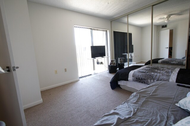 bedroom with a closet, carpet, a textured ceiling, baseboards, and visible vents