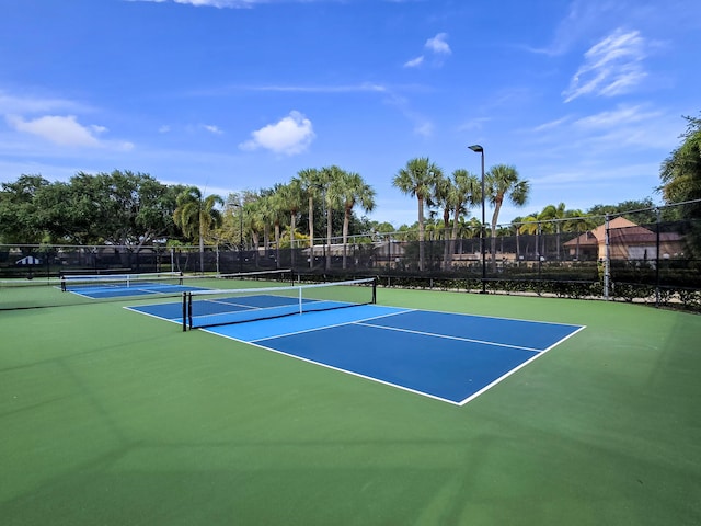 view of tennis court with fence and community basketball court