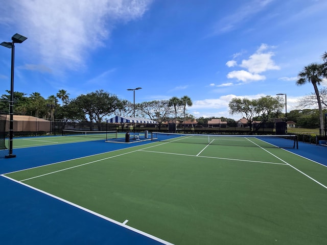 view of tennis court featuring fence and community basketball court