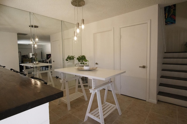 tiled dining room with a textured ceiling