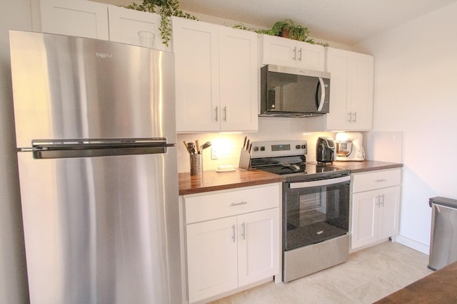 606 6th Way, West Palm Beach, FL 33407 - kitchen featuring appliances with stainless steel finishes, white cabinets, and butcher block counters