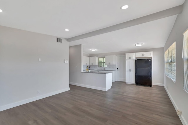 kitchen featuring freestanding refrigerator, white cabinetry, a sink, baseboards, and dark wood finished floors