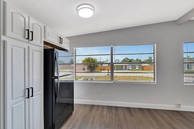 kitchen with freestanding refrigerator, light wood finished floors, baseboards, white cabinetry, and lofted ceiling