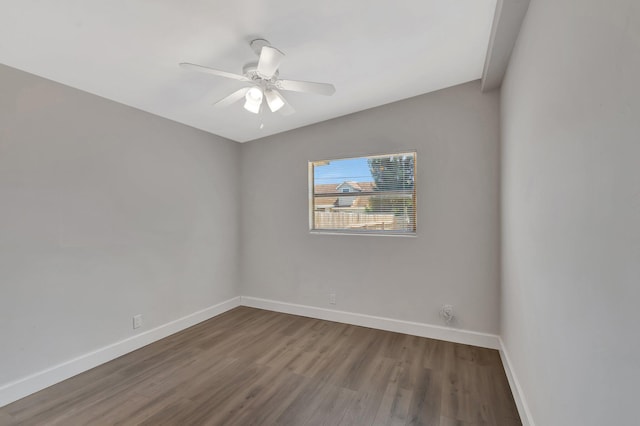 spare room featuring baseboards, wood finished floors, and a ceiling fan