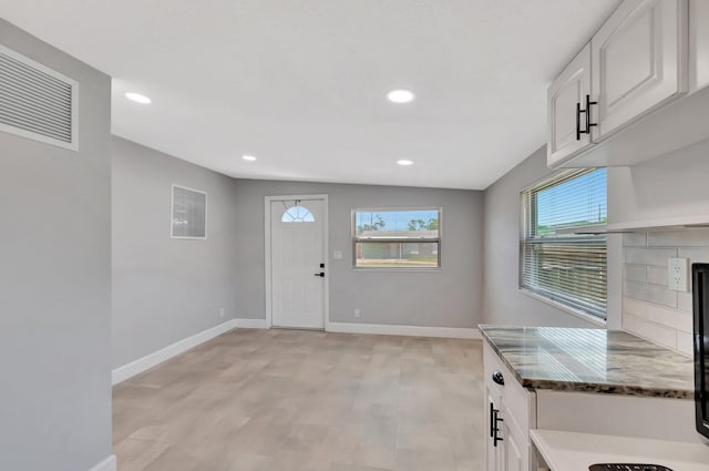 foyer featuring baseboards, recessed lighting, light wood finished floors, and a tile fireplace