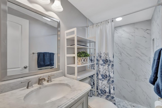 bathroom with a shower stall, vanity, and toilet