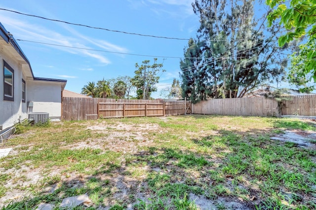 fenced backyard featuring central AC