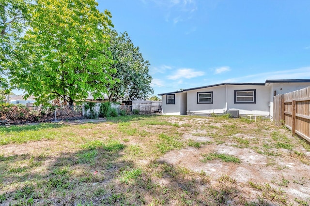 fenced backyard featuring central AC unit