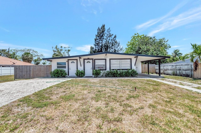 ranch-style house with stucco siding, driveway, and an attached carport