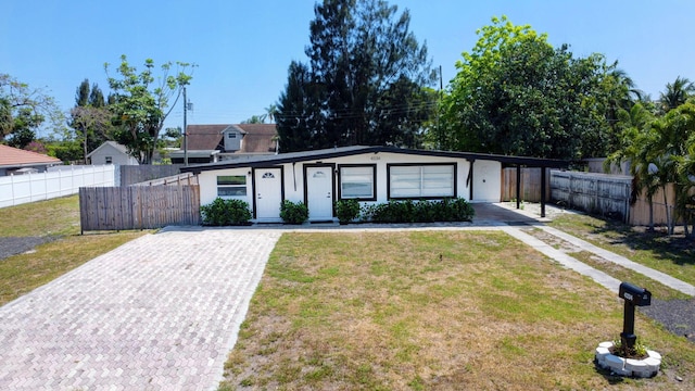 view of front of house featuring driveway, a carport, and stucco siding