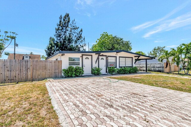 ranch-style home featuring stucco siding and driveway