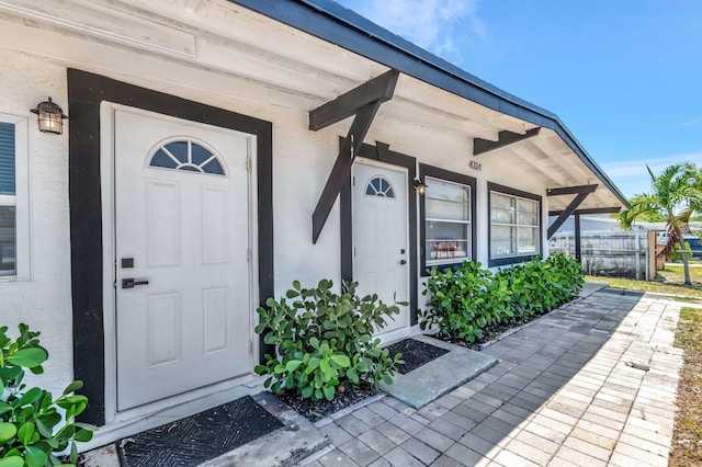 entrance to property with stucco siding and covered porch