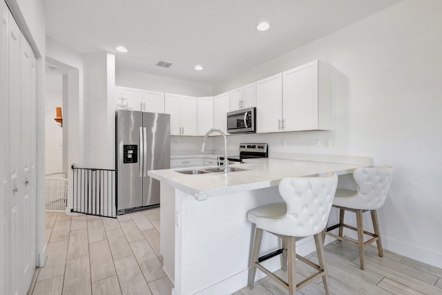 4006 Sequoia Pl W, Riviera Beach, FL 33410 - kitchen featuring stainless steel appliances, a sink, a peninsula, light countertops, and a breakfast bar