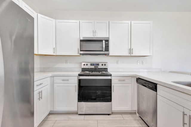 4006 Sequoia Pl W, Riviera Beach, FL 33410 - kitchen with appliances with stainless steel finishes, light countertops, white cabinets, and light tile patterned flooring
