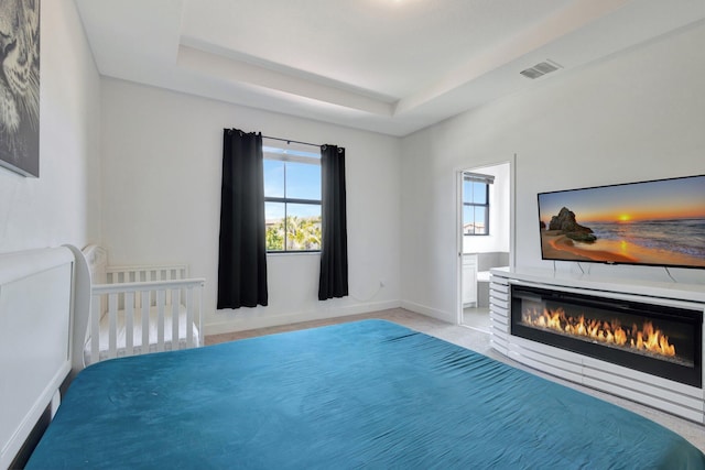4006 Sequoia Pl W, Riviera Beach, FL 33410 - bedroom with multiple windows, a glass covered fireplace, a tray ceiling, and baseboards