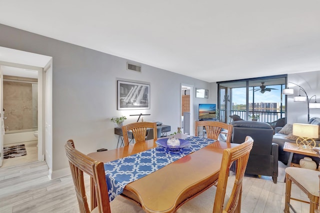 113 Lake Emerald Dr Unit 409, Oakland Park, FL 33309 - dining area with light wood-style flooring, ceiling fan, baseboards, and a wall of windows