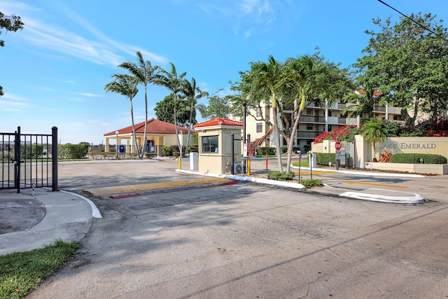 113 Lake Emerald Dr Unit 409, Oakland Park, FL 33309 - view of asphalt street with traffic signs, a gate, a gated entry, curbs, and sidewalks