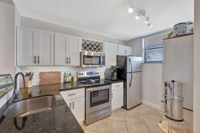 113 Lake Emerald Dr Unit 409, Oakland Park, FL 33309 - kitchen featuring appliances with stainless steel finishes, a sink, backsplash, light tile patterned floors, and white cabinetry