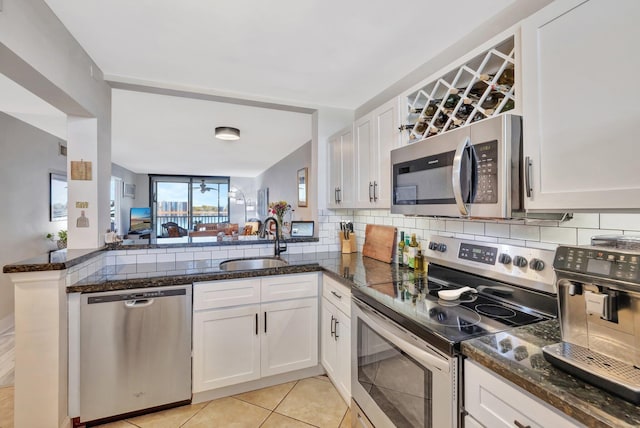 113 Lake Emerald Dr Unit 409, Oakland Park, FL 33309 - kitchen with appliances with stainless steel finishes, a sink, tasteful backsplash, white cabinets, and light tile patterned floors